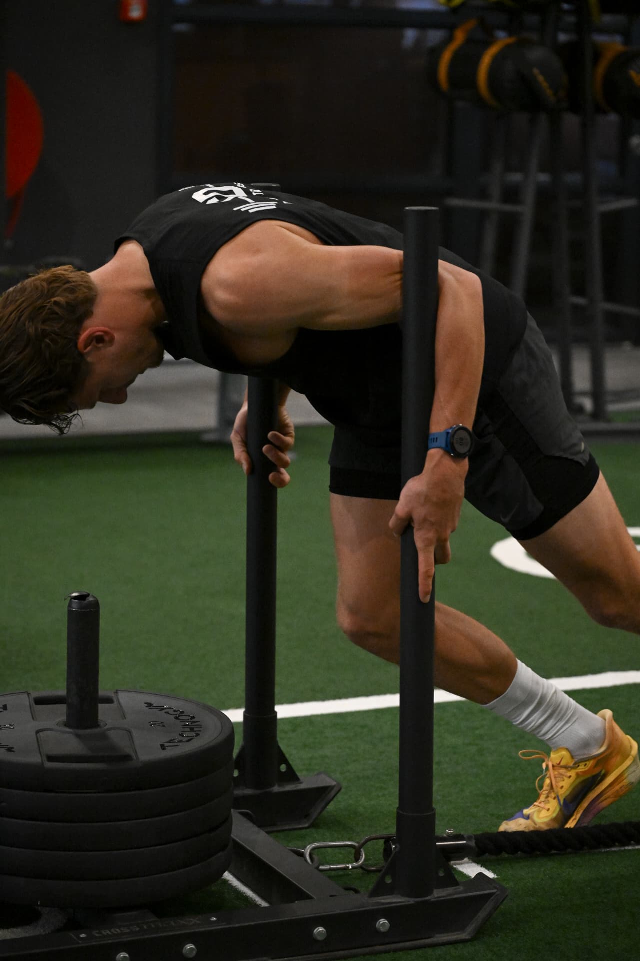 Klant voert een sled push uit tijdens personal training